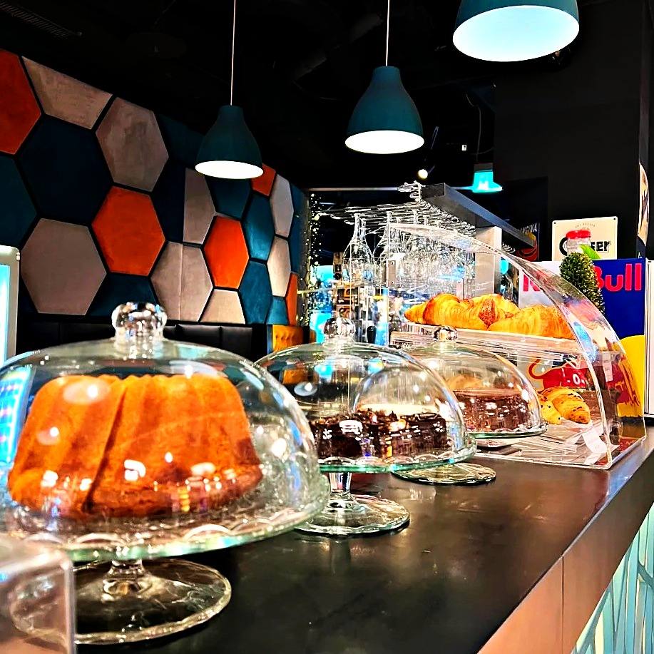 Kuchenvitrine mit Gugelhupf, Brownies und Croissants unter Glashauben